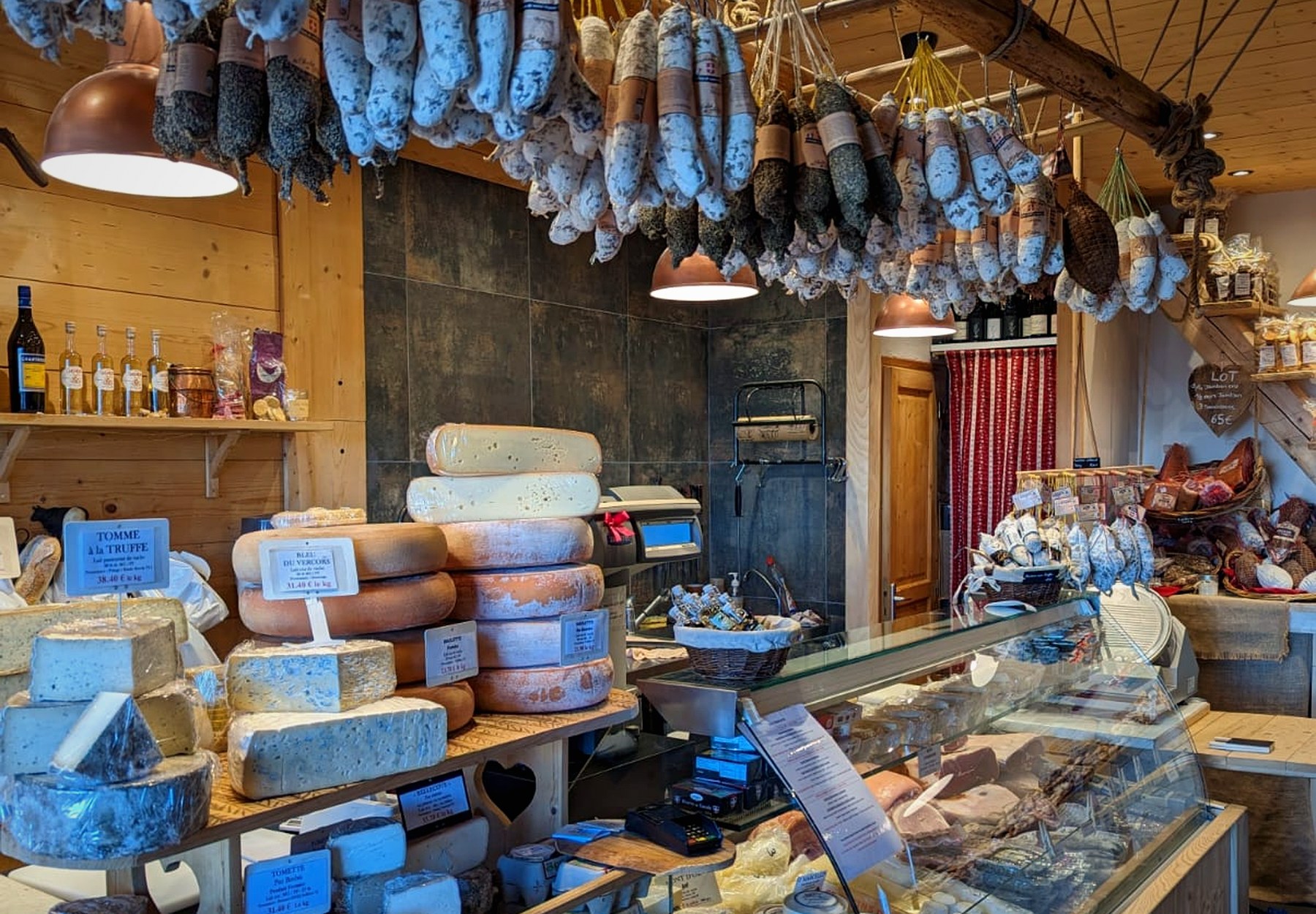 Inside the shop, cheeses and hanging sausages